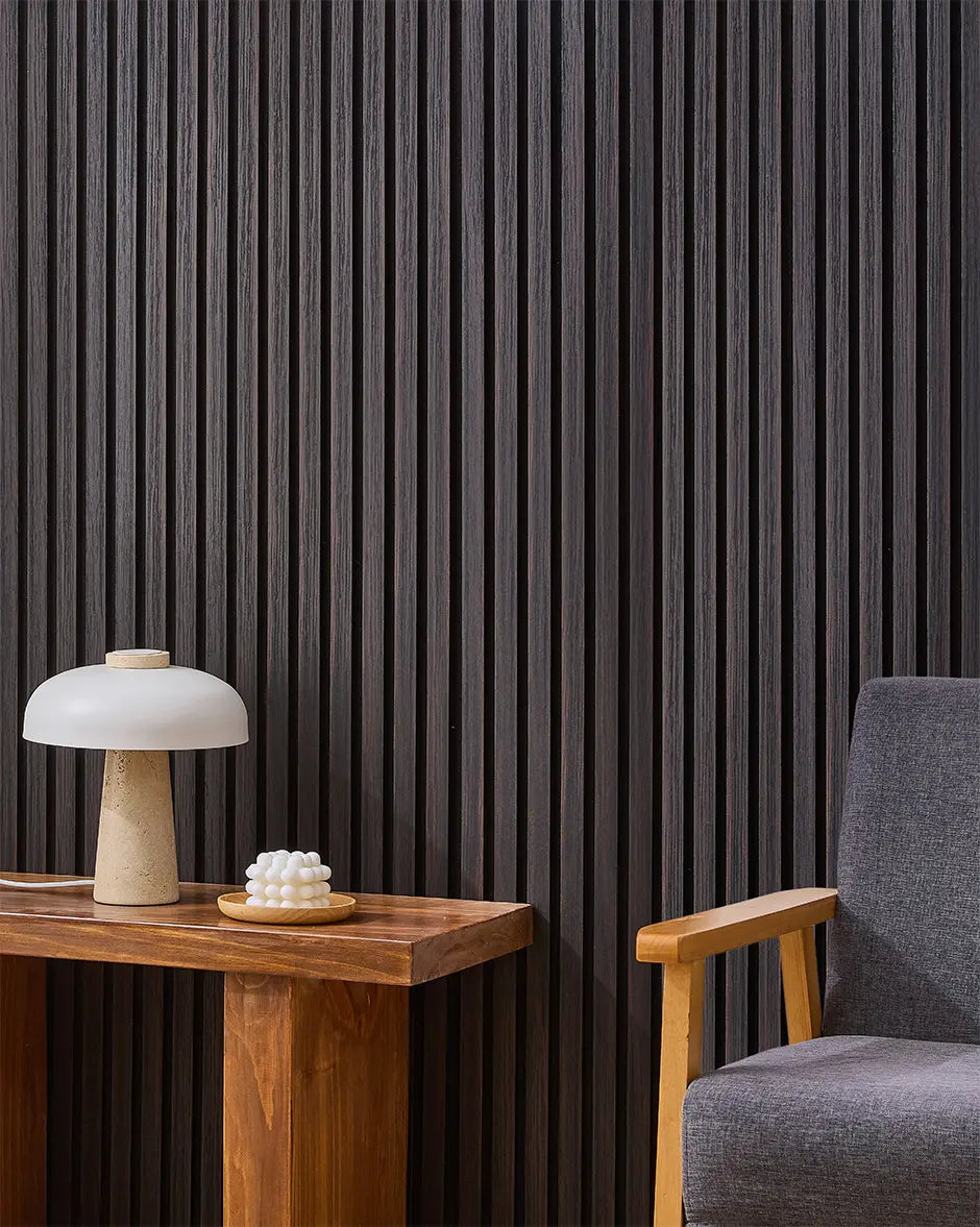 Dark Walnut NORDAN acoustic slat wood wall panels installed as a feature wall in a reading corner.