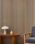 Oak NORDAN acoustic slat wood wall panels installed as a feature wall in a reading corner.