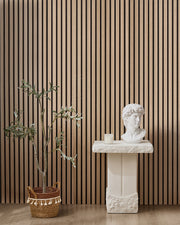 Oak NORDAN acoustic slat wood wall panels installed as a feature wall in a styled interior space.