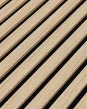 Close-up of the oak woodgrain finish and vertical slat texture on NORDAN acoustic wall panels.