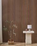 Teak NORDAN acoustic slat wood wall panels installed as a feature wall in a styled interior space.