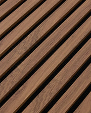 Close-up of the teak woodgrain finish and vertical slat texture on NORDAN acoustic wall panels.