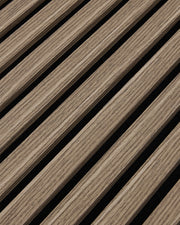 Close-up of the walnut woodgrain finish and vertical slat texture on NORDAN acoustic wall panels.